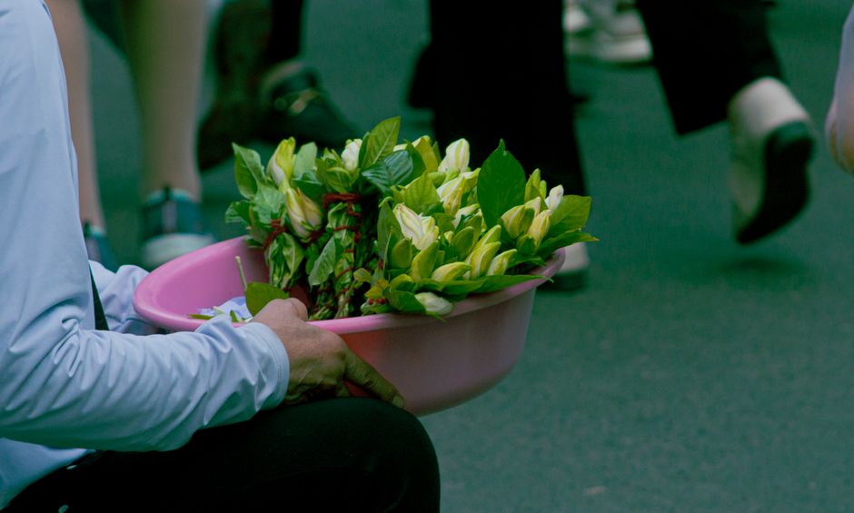 小さな骨壷とお花を前に静かに手を合わせるイメージ